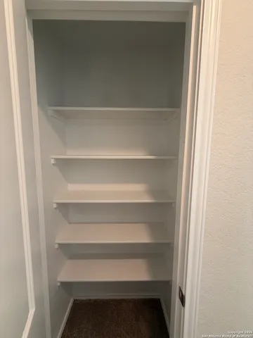 a view of walk in closet with empty racks