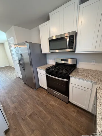 a kitchen with granite countertop a stove and a microwave