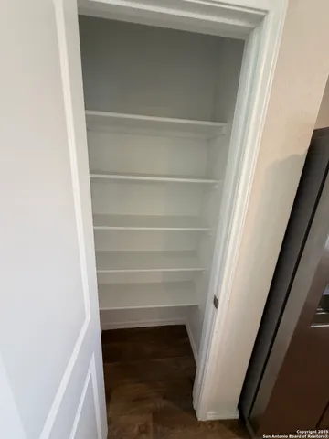 a view of walk in closet with empty racks