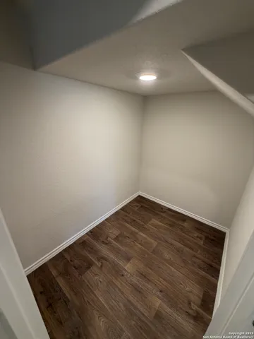 a view of a room with wooden floor and white walls