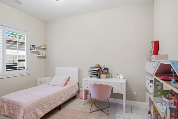a bedroom with a bed wooden floor and a window