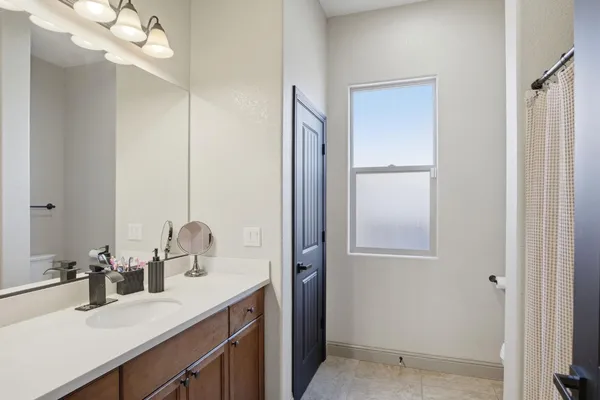 a bathroom with a sink a light fixture and a mirror