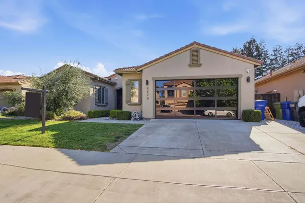 a front view of a house with a yard and potted plants