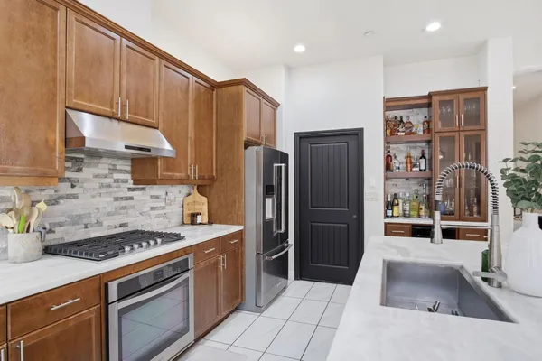 a kitchen with stainless steel appliances granite countertop a refrigerator and a stove