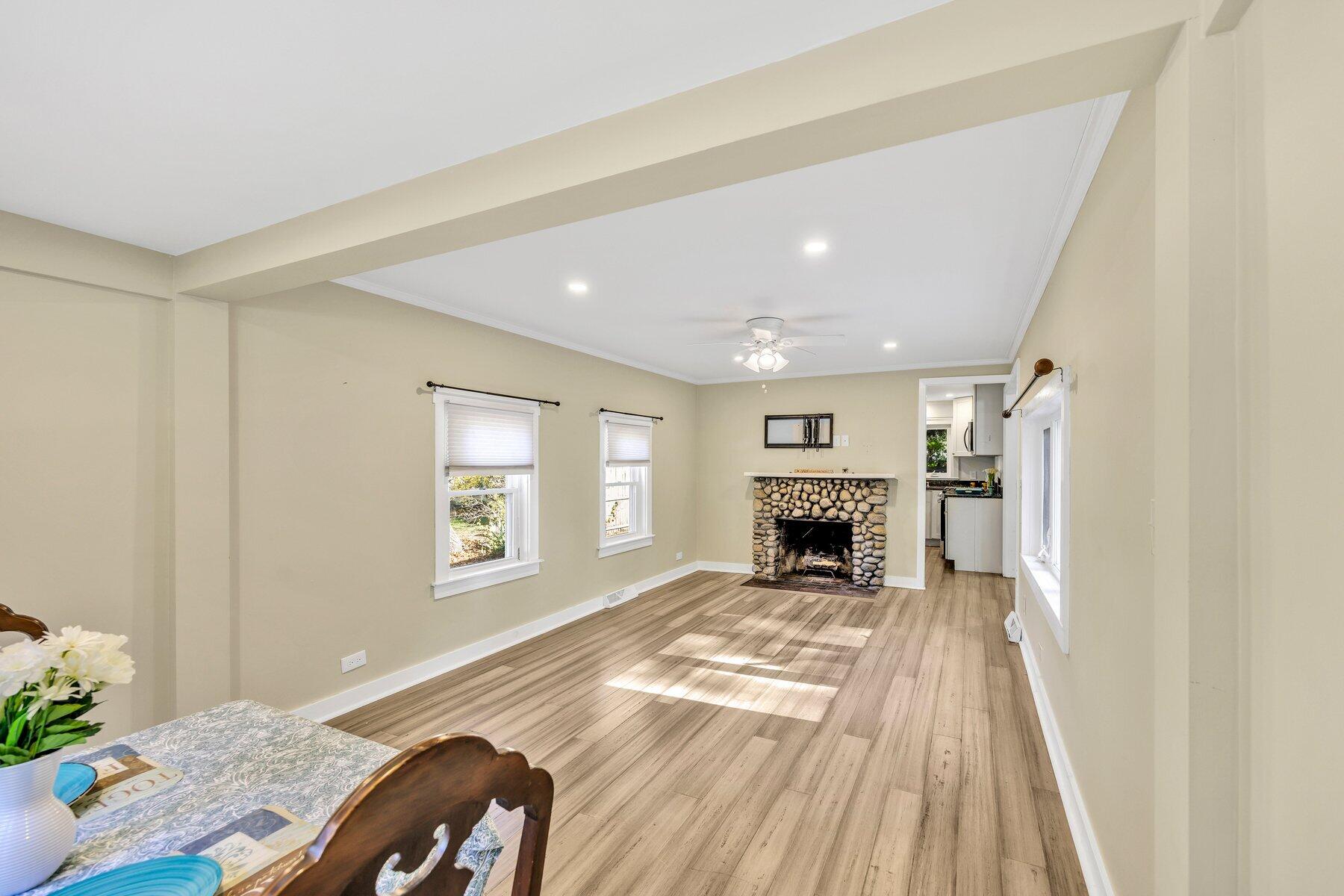576 Strawberry Hill Road Centerville, MA 02632 - Photo 13 of 38 a view of a livingroom with a fireplace a ceiling fan and wooden floor