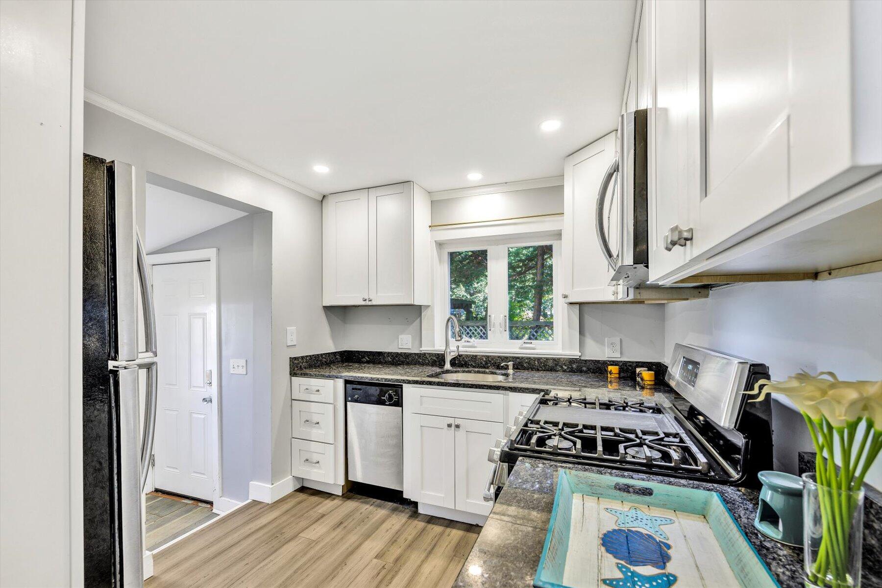 576 Strawberry Hill Road Centerville, MA 02632 - Photo 5 of 38 a kitchen with granite countertop stainless steel appliances a stove a sink a refrigerator cabinets and wooden floor