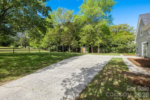 a view of a yard with plants and trees
