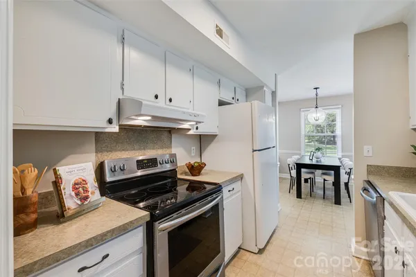 a kitchen with stainless steel appliances granite countertop a stove and a refrigerator