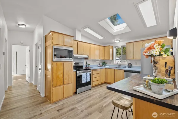 a kitchen with granite countertop stainless steel appliances and wooden cabinets