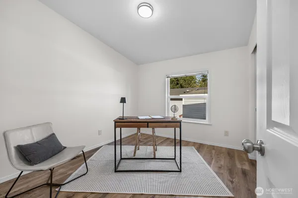 a view of a workspace with furniture and a window