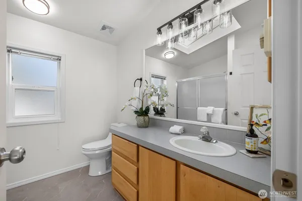 a bathroom with a granite countertop sink and a mirror