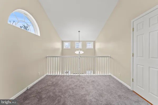an empty room with staircase and white walls