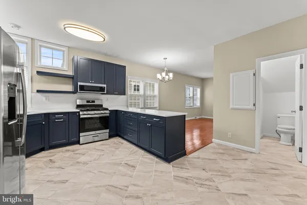a kitchen with stainless steel appliances kitchen island granite countertop a refrigerator and a stove top oven