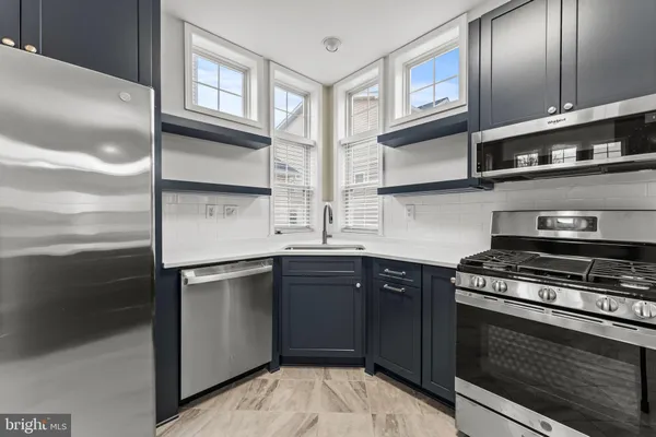 a kitchen with stainless steel appliances granite countertop a stove and a sink