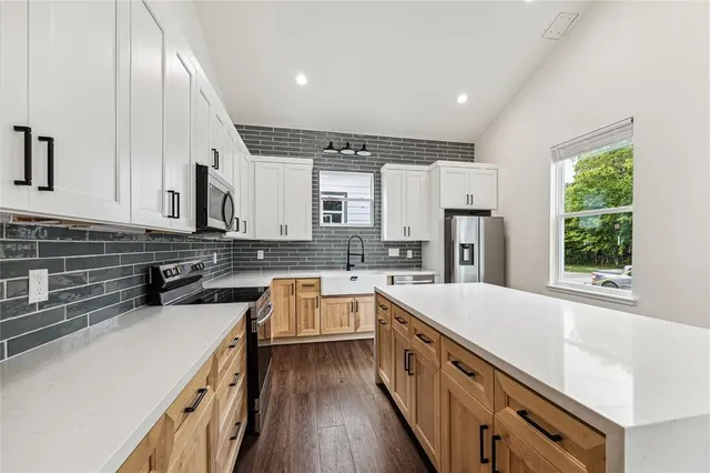 a kitchen with stainless steel appliances sink refrigerator and microwave