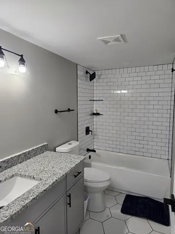 a kitchen with stainless steel appliances kitchen island granite countertop a refrigerator a stove and a wooden floors