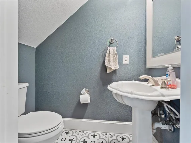 a bathroom with a sink a toilet and a mirror