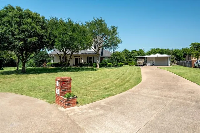 a view of a house with garden and a trees