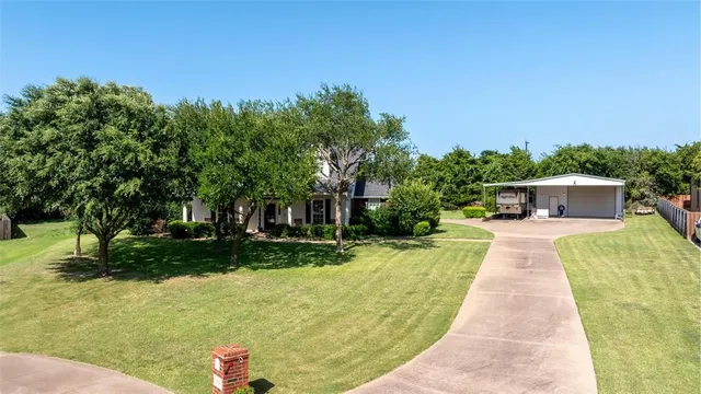 a front view of a house with a yard and trees