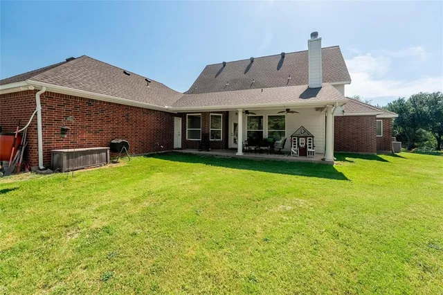 a view of a house with a yard and sitting area