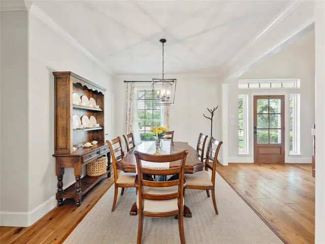 a dining room with furniture a chandelier and wooden floor