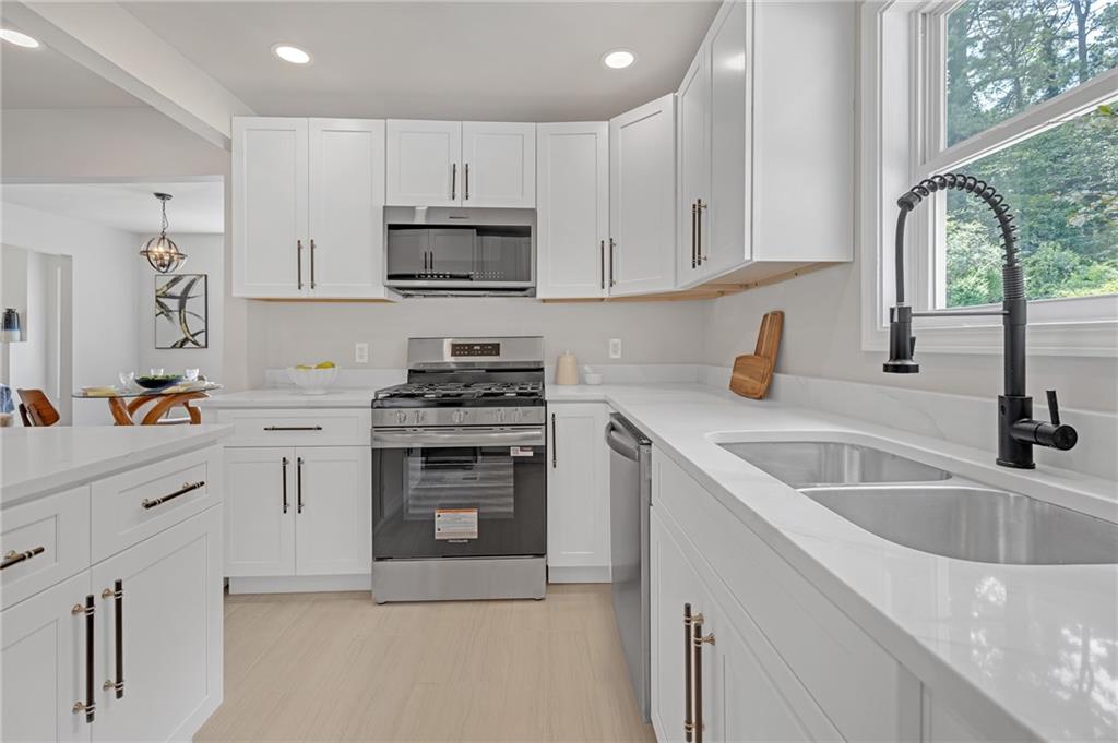 656 South Elizabeth Place Northwest Atlanta, GA 30318 - Photo 1 of 1 a kitchen with white cabinets sink and stainless steel appliances