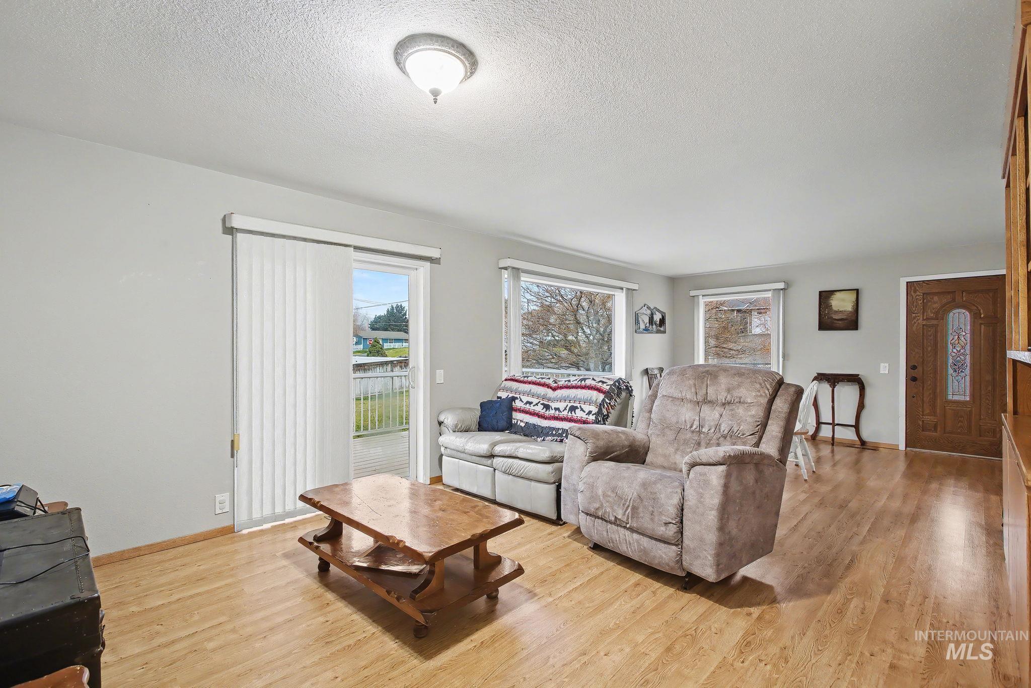 1103 3rd Street Asotin, WA 99402 - Photo 14 of 44 Living area featuring a textured ceiling, light wood-style floors, and healthy amount of natural light