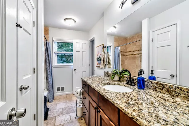 a bathroom with a granite countertop sink mirror and vanity
