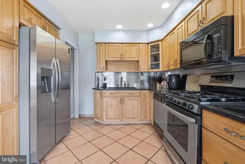 a kitchen with stainless steel appliances granite countertop a stove a refrigerator and a microwave