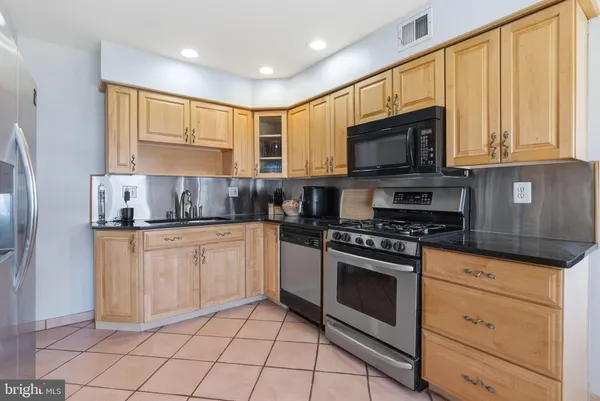 a kitchen with stainless steel appliances a refrigerator and cabinets