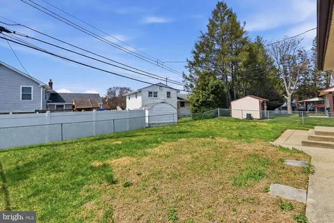 a view of a backyard with grass and brick wall
