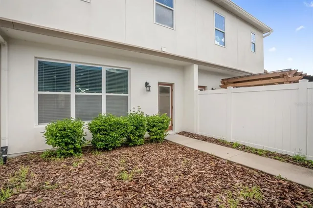 a house with a lot of plants in front of it
