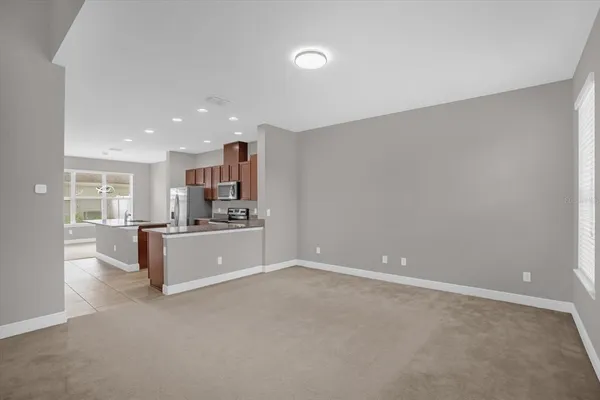 a large white kitchen with kitchen island a sink stainless steel appliances and cabinets