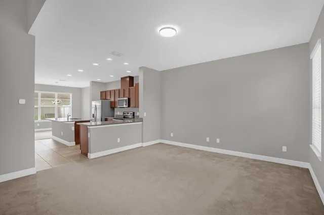 a large white kitchen with kitchen island a sink stainless steel appliances and cabinets