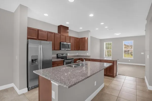 a kitchen with stainless steel appliances granite countertop a sink a stove and a refrigerator