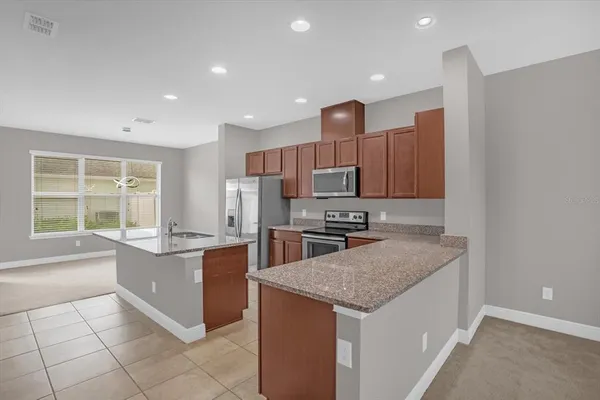a kitchen with stainless steel appliances granite countertop a sink and a stove