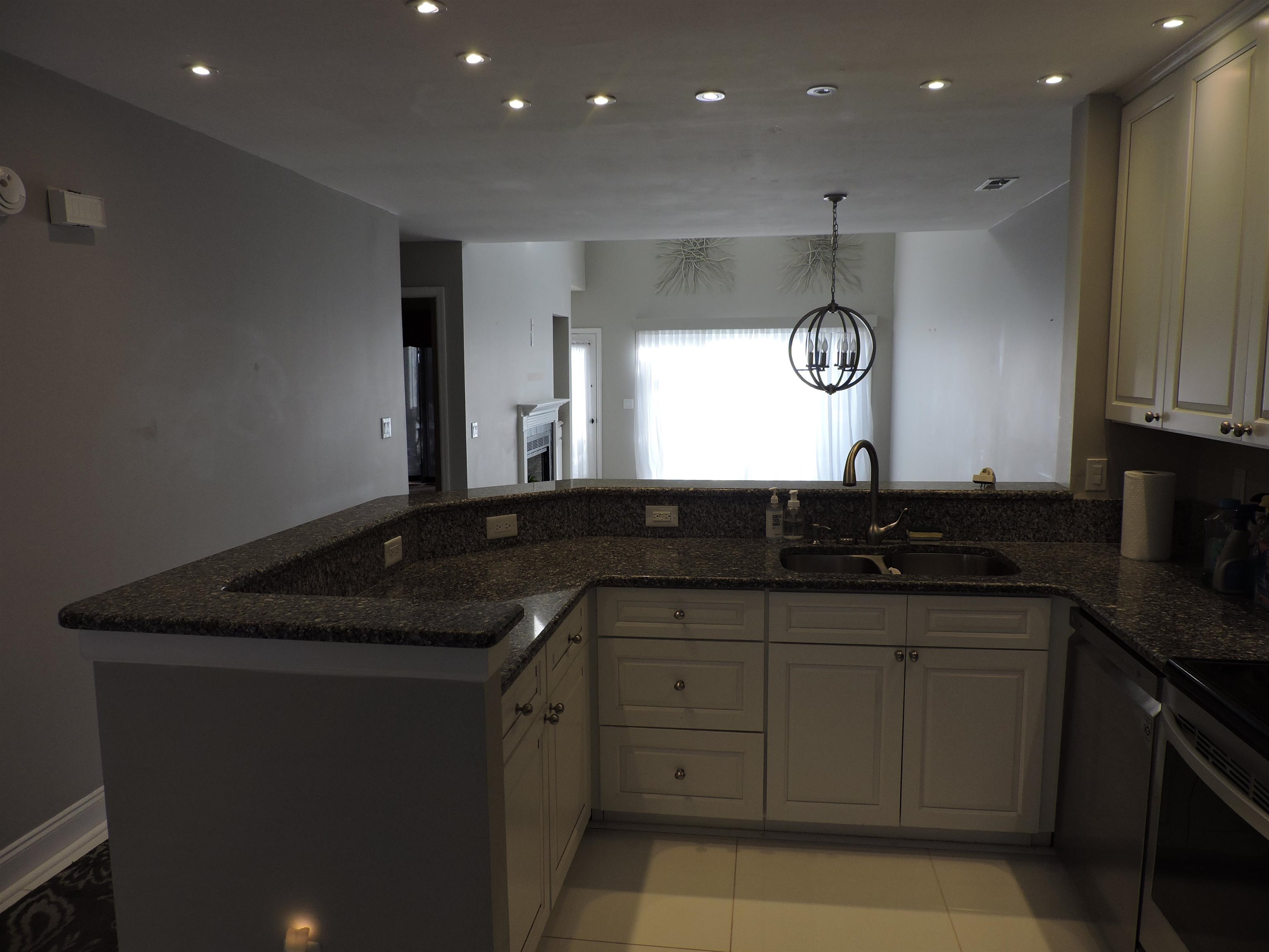 4396 Baldwin Avenue, Unit 80 Little River, SC 29566 - Photo 10 of 40 Kitchen with a peninsula, dark stone counters, recessed lighting, a chandelier, and appliances with stainless steel finishes