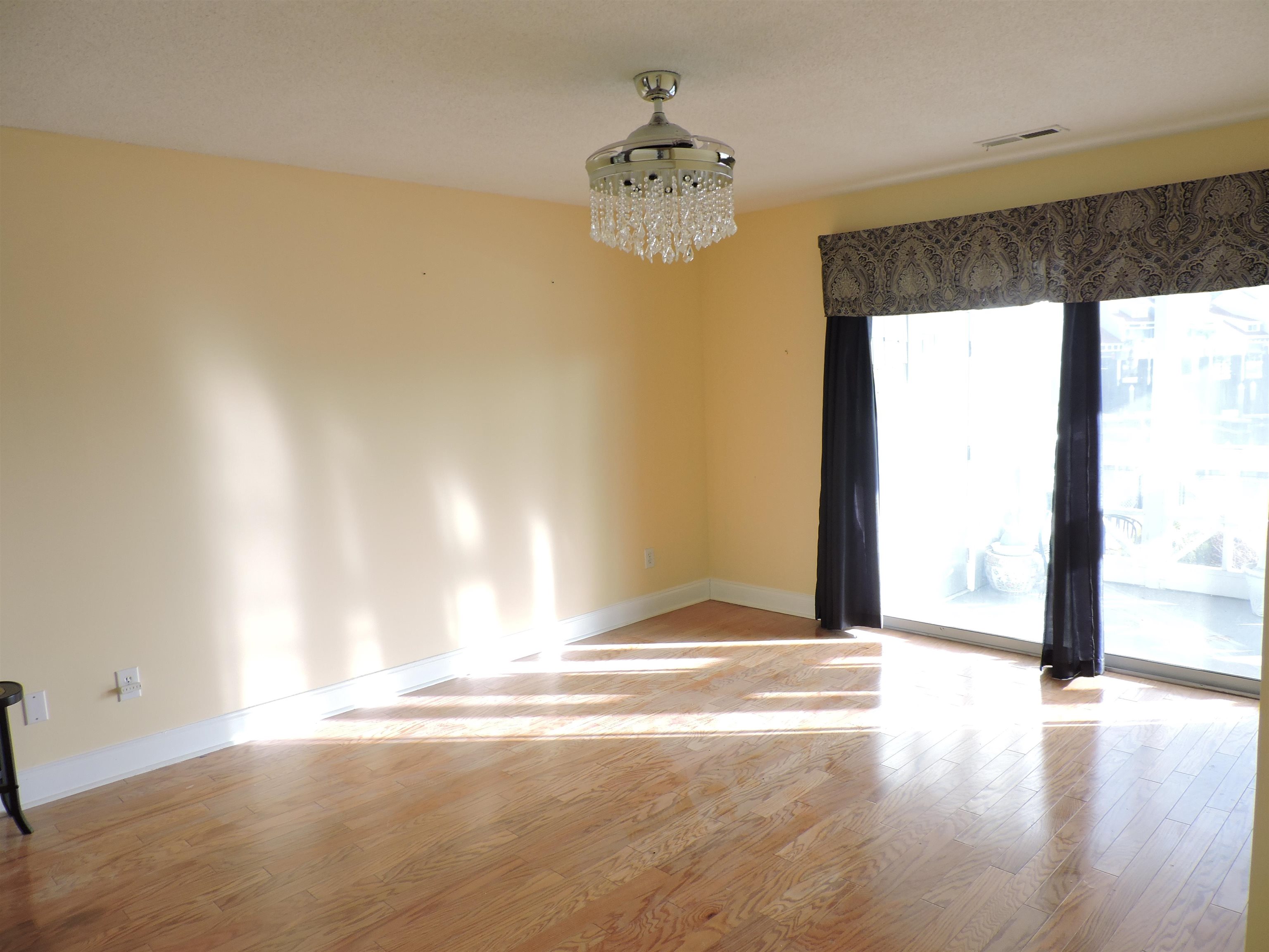 4396 Baldwin Avenue, Unit 80 Little River, SC 29566 - Photo 22 of 40 Empty room with a chandelier and light wood finished floors