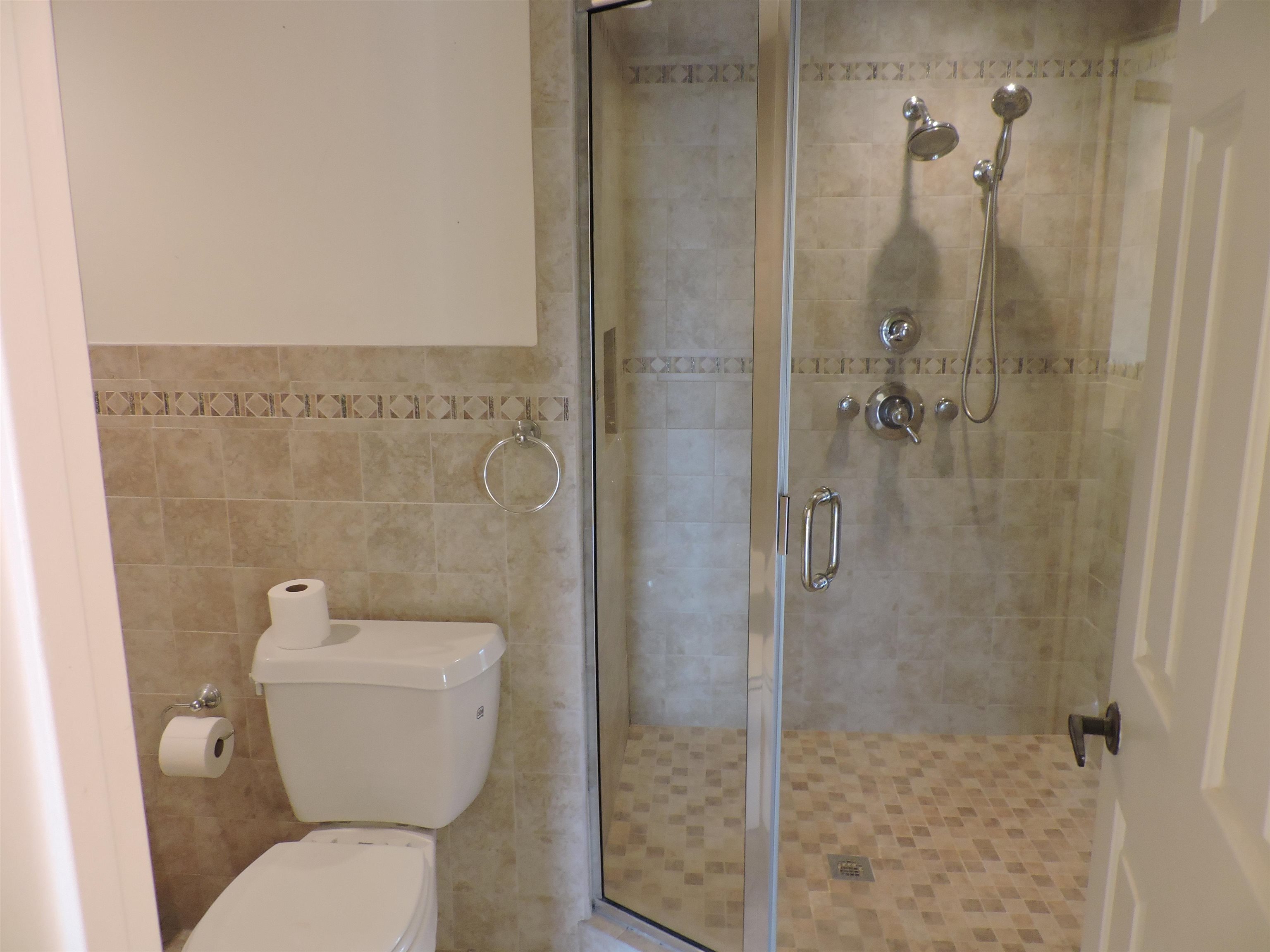 4396 Baldwin Avenue, Unit 80 Little River, SC 29566 - Photo 25 of 40 Full bath with tile walls, a shower stall, and wainscoting