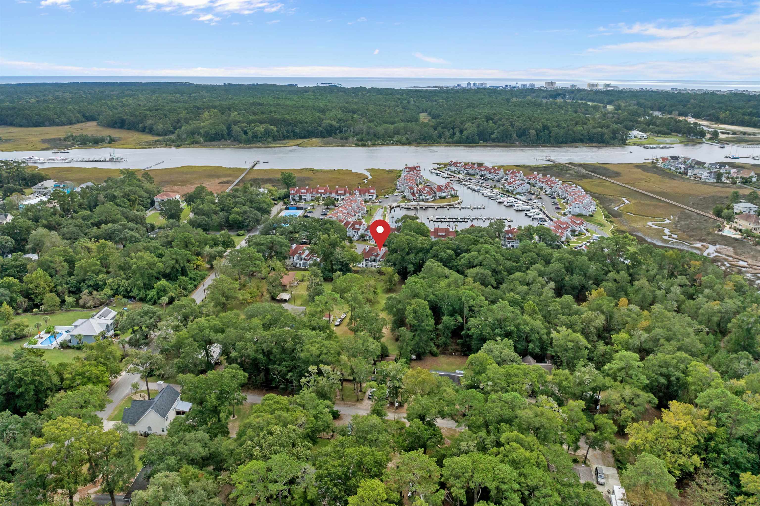 4396 Baldwin Avenue, Unit 80 Little River, SC 29566 - Photo 8 of 40 Aerial view of property's location featuring a nearby body of water and a heavily wooded area