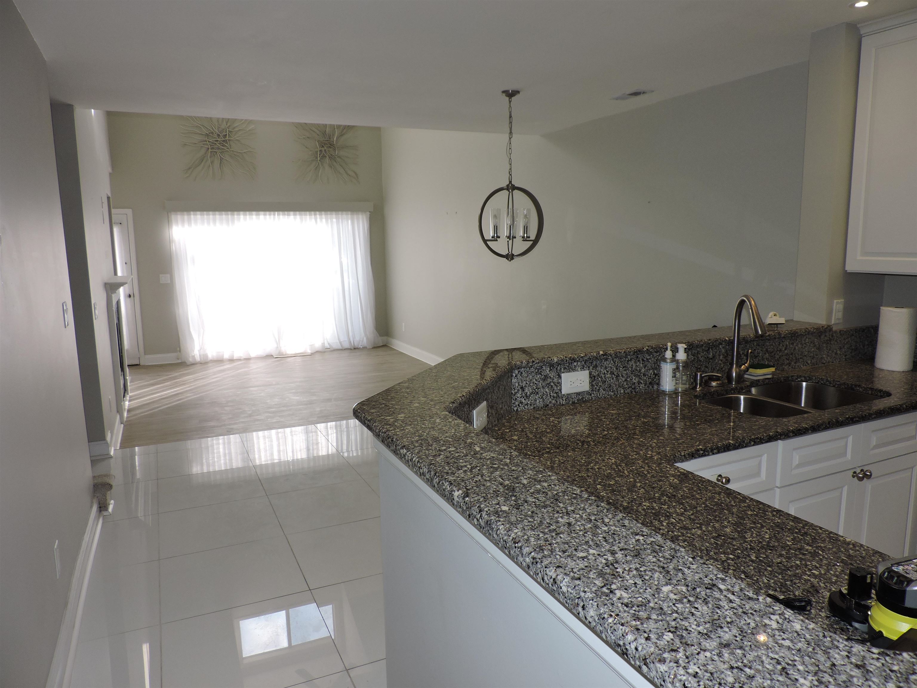 4396 Baldwin Avenue, Unit 80 Little River, SC 29566 - Photo 40 of 40 Kitchen with dark stone counters, white cabinetry, light tile patterned floors, open floor plan, and hanging light fixtures