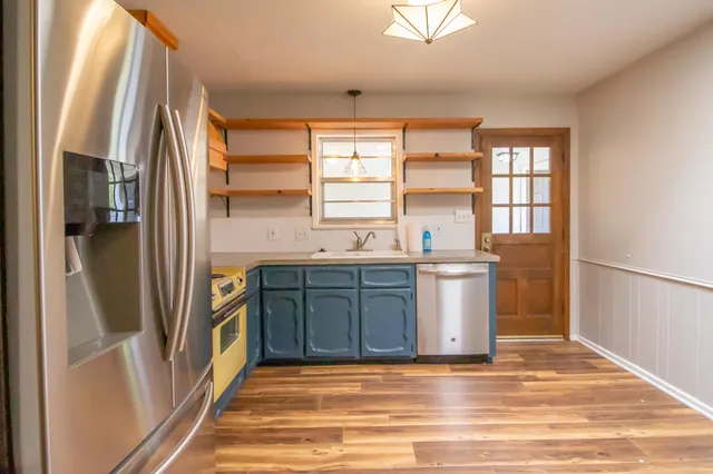 a kitchen with stainless steel appliances granite countertop a refrigerator a sink and a stove