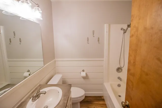 a bathroom with a granite countertop sink toilet and shower