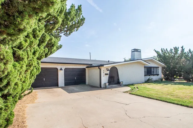 a front view of a house with a garden and yard