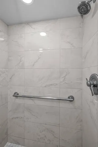 a bedroom with a bed and a large mirror on the dresser