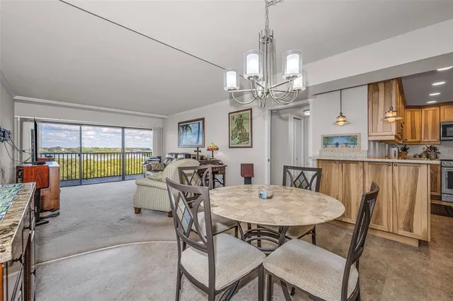 a view of a dining room with furniture a chandelier and wooden floor