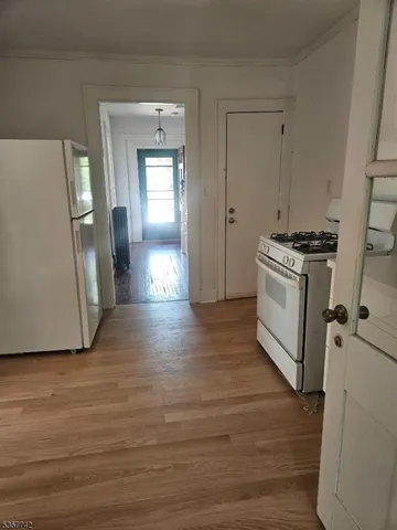 a kitchen with a wooden floor and white cabinets