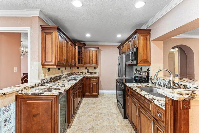 a kitchen with stainless steel appliances granite countertop a sink stove and cabinets