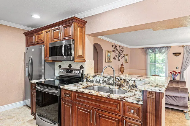 a kitchen with stainless steel appliances a stove microwave and sink