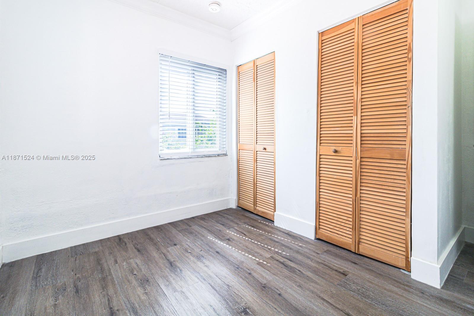 15600 Northwest 157th St Road Miami Gardens, FL 33054 - Photo 18 of 25 an empty room with wooden floor and windows